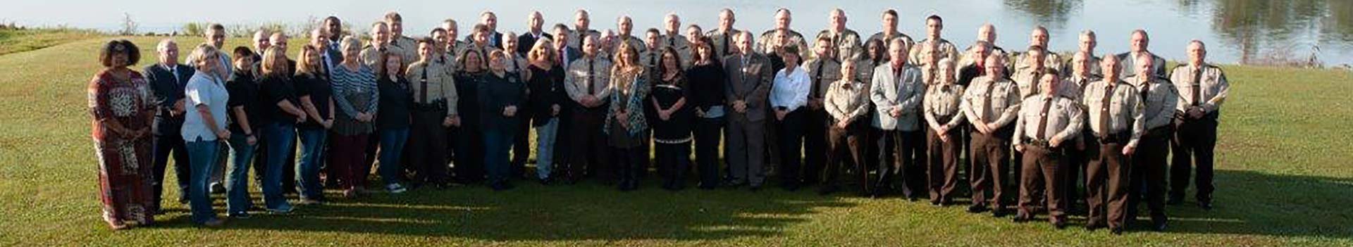 St. Clair County Sheriff’s Office staff in work uniforms standing in the grass in front of the lake